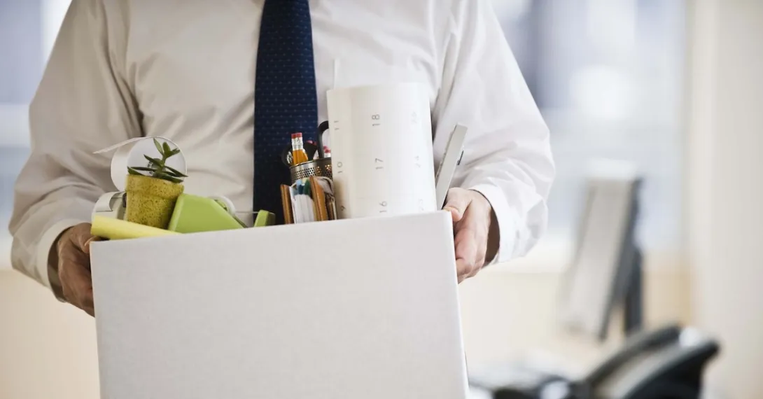 A worker holding a box of belongings.
A worker holding a box of belongings.