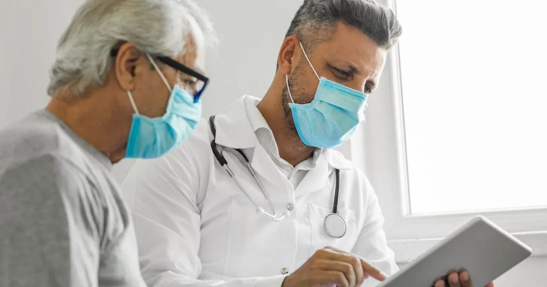 
  Healthcare provider and patient sitting together looking at a tablet
