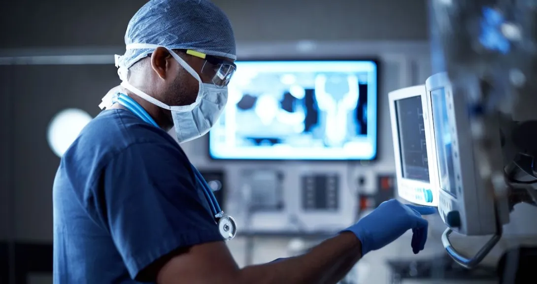 
  Healthcare provider in scrubs standing in front of an imaging screen
