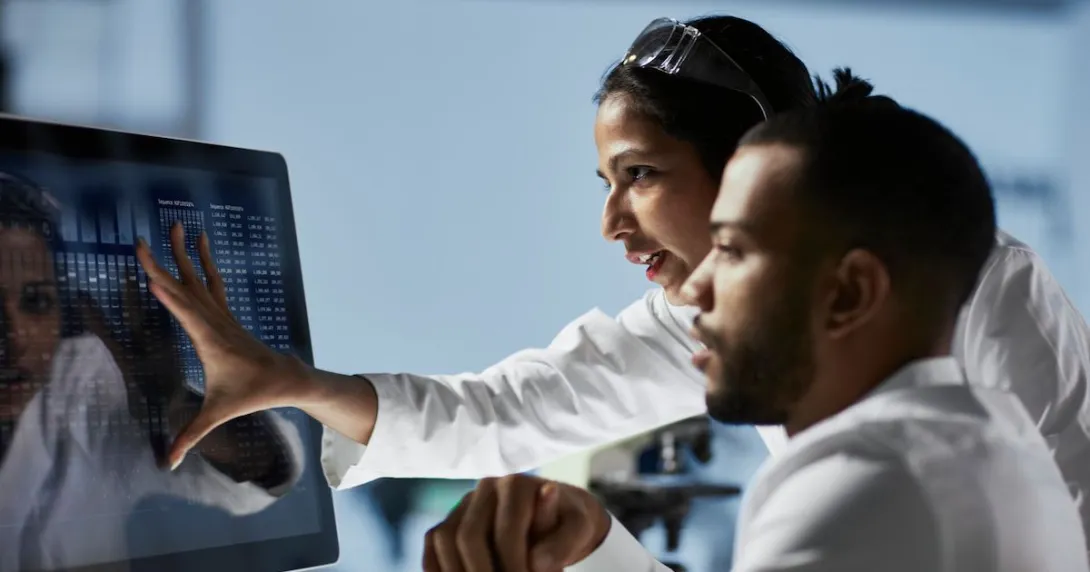 Doctors looking at patient data on a monitor Doctors looking at patient data on a monitor