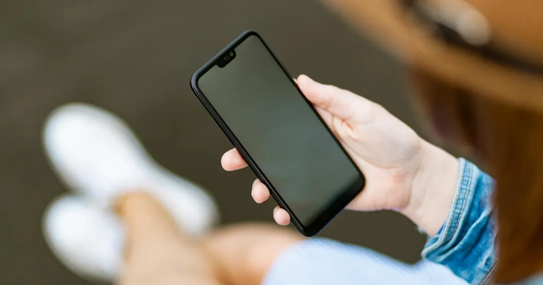 Person holding a smartphone Person holding a smartphone
