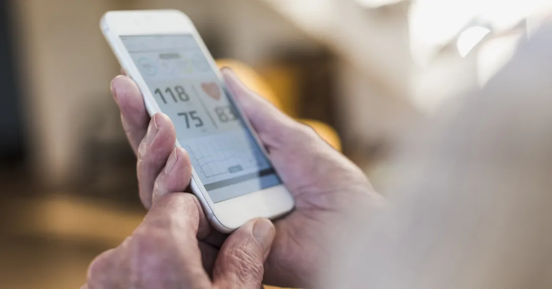 A smartphone displaying blood pressure data and a chart with trends